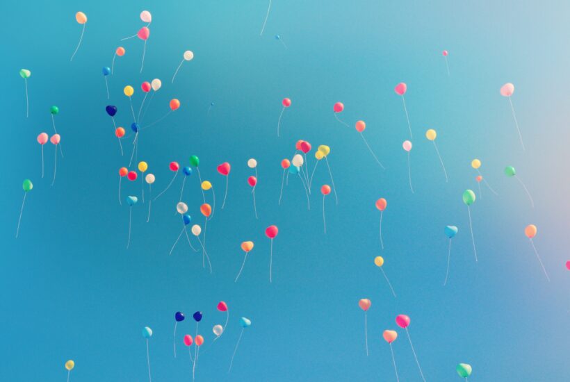 Colourful balloons floating in blue sky