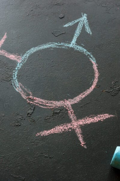 Symbol of a transgender and female and male gender symbols drawn with chalk on a black background